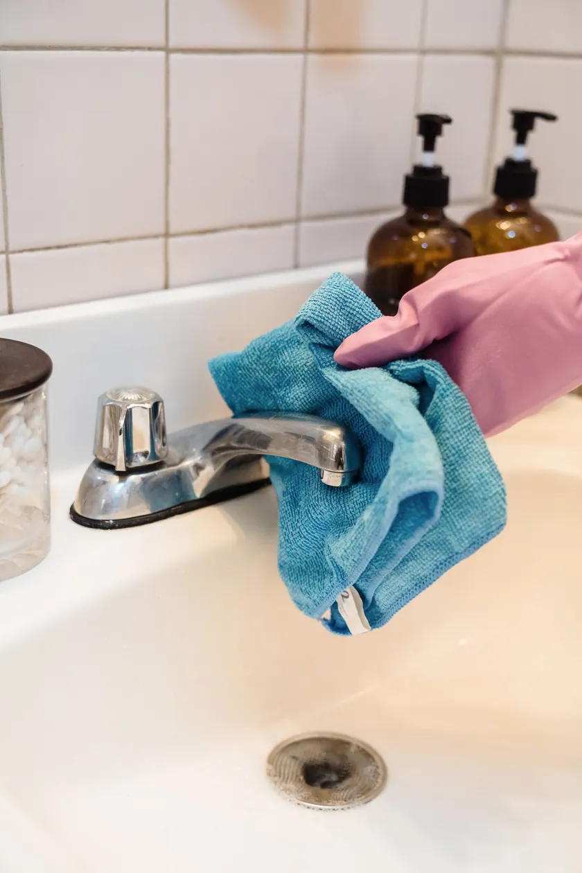 Manos manteniendo una grifería de baño