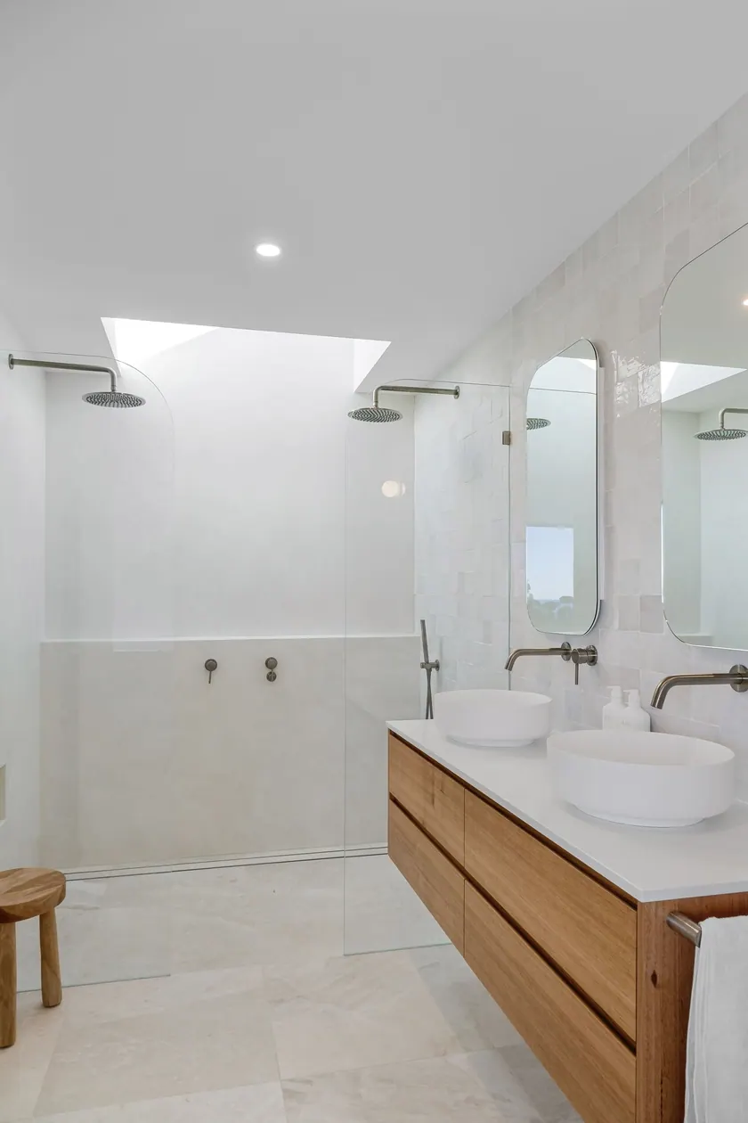 Baño moderno con duchas y varios lavabos